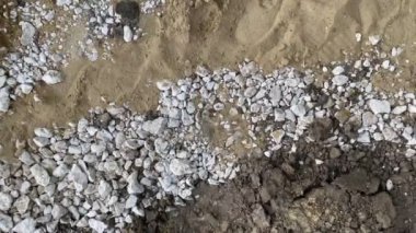 Kum ve toprak arasında beyaz çakıl