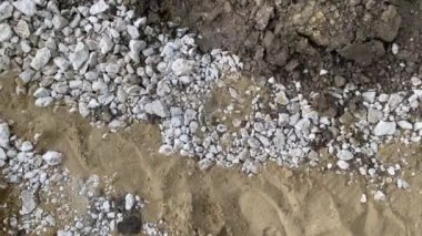 Kum ve toprak arasında beyaz çakıl