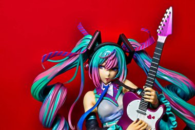 OSAKA,JAPAN - JULY 10, 2023 : Studio shot of a statue of Miku Hatsune strumming an electric guitar at a live performance of the 