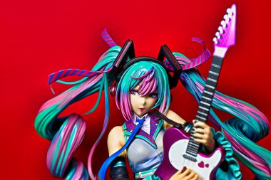 OSAKA,JAPAN - JULY 10, 2023 : Studio shot of a statue of Miku Hatsune strumming an electric guitar at a live performance of the 