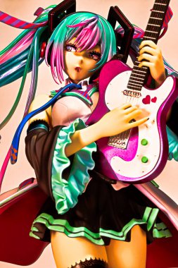 Osaka,Japan - June 7, 2023 : Studio shot of a statue of Miku Hatsune strumming an electric guitar at a live performance of the 