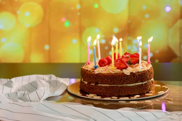 Happy birthday cake with candle lights. Healthy carrot cake with fruits on top. Birthday concept.