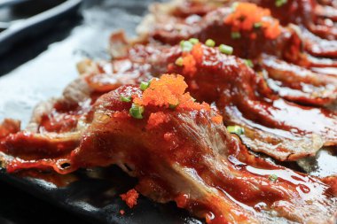 Yakın plan suşi domuz eti bulgogi Kore soslu ve siyah tabakta. Kore Gıda Konsepti.