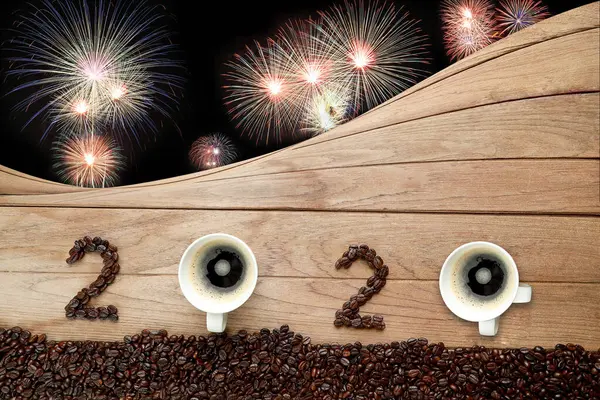 Coffee beans and hot fresh coffee in a white cup with foam and text number design 2024 for Happy New Year Concept. with fireworks background.