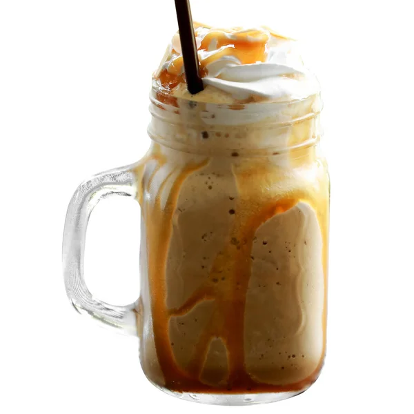 Iced Coffee Caramel Macchiato Frappe with whipping cream on top in the mug glass on white background.