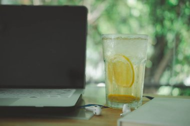 Limonlu buzlu çay bardağa konmuş ve masada bilgisayar varmış. Gündüz dinlenme konsepti