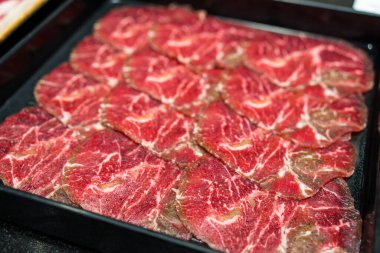 Çiğ et dilimi Shabu shabu için siyah tepside hazır.