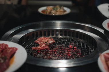 Mangal için çiğ et dilimi ya da Japon usulü yakiniku yemek barbeküsü ve fırında mangal kömürü.