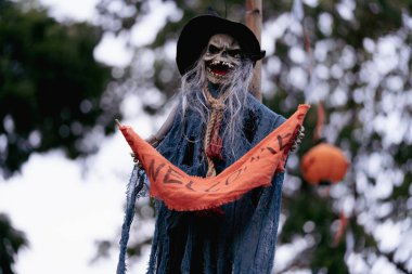 Perili evin ön bahçesinde asılı hayalet bebek cadılar bayramı kutlamaları için bulanık doğal ağaçtaki Cadılar Bayramı partisi için süslenmişti.