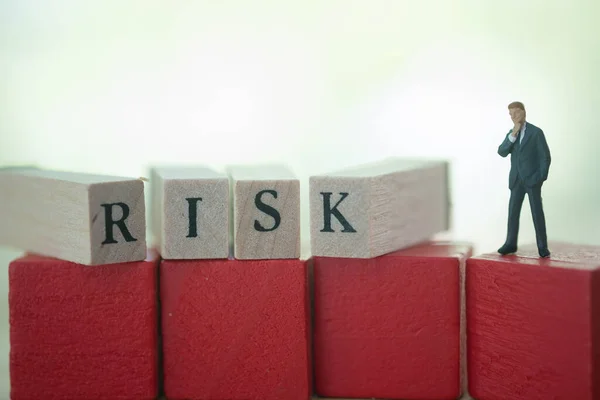 Miniaturowy Biznesmen Stoi Kostkach Czerwonego Drewna Słowem Risk Koncepcja Kontroli — Zdjęcie stockowe