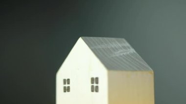 Rotate of miniature wood house on a black background. Real estate home mortgage or buying concept. Business financial and loan