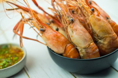 Kaynamış nehir karidesini siyah kaseye koy, Tayland usulü ev yapımı deniz ürünleri..