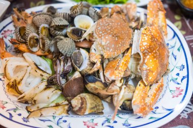 Izgara deniz ürünleri seti arasında midye, yengeç, karides, mürekkep balığı ve Benekli Babil vardır. Kapat.