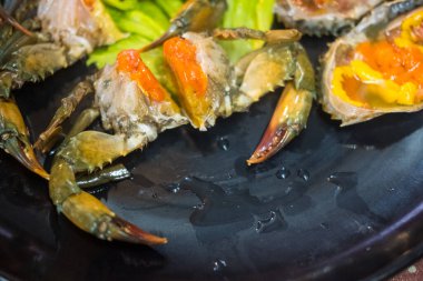 Donmuş çiğ deniz yengeci ve siyah tabakta yumurtalar. Tayland deniz ürünleri