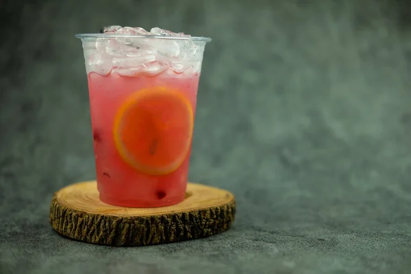 プラスチック製のガラスに氷とレモンのスライスとピンクのレモネード 夏の飲み物 — ストック写真