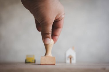 Ev ve araba kredisi için el damgası onaylama, kredi onaylama süreci. Borç konsepti borçluya yardımcı olur. Ahşap ev ve arabanın el yazısı ve arka planı.