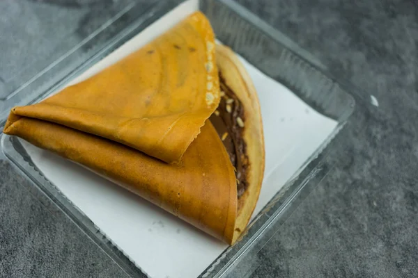 ホットストーブにクレープ粉を薄い層に広げ チョコレートペーストやカシューナッツなどのトッピングをボックスに入れてクリスピークレープパンケーキのレシピ — ストック写真