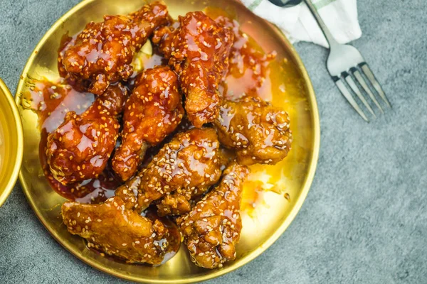 Deep-fried chicken wings or barbecue sprinkled with sesame. Spicy Korean-style fried chicken. Top view