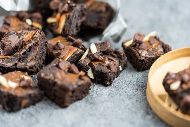 Dilimlenmiş badem ve çikolata parçalı siyah çikolatalı browni. Kapat.