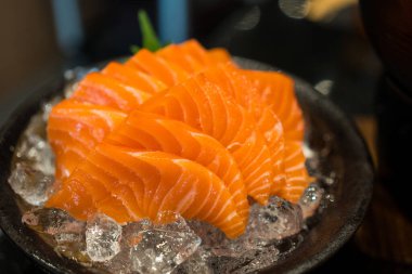 Eller somon balığını tutmak için çubuk kullanır. Sashimi buzda yapılmıştı. Kapat.