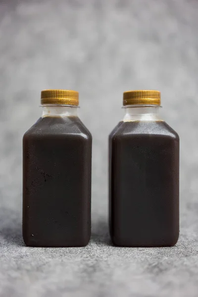Cold brew coffee in plastic bottle with golden lid, two bottles. Close up