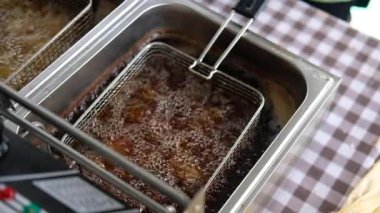 Kızartma makinesinde kızgın yağlı tavuğun yavaş çekim görüntüsü.