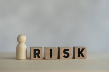 Tahta bebek ve RİSK tahta bloğu. Risk değerlendirmesi, iş görüşmelerini kabul etme kararı belirsizlik, öngörülemez durum konsepti. Risk yönetimi kavramı.