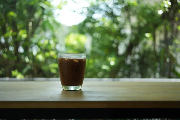 Iced mocha. A glass cup of espresso mixed with chocolate or cocoa on table at coffee cafe.