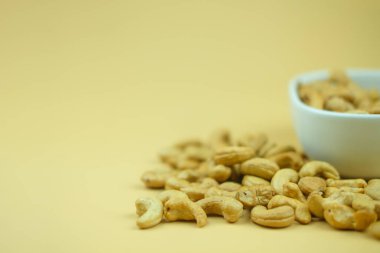 Fotokopi alanı olan sarı bir arka planda kavrulmuş kaju fıstığı..