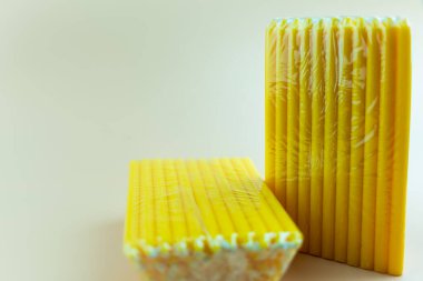 Sarı mum pakette satışa hazır bekliyor. Kapat.