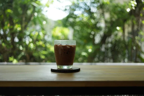 Ice Mocha coffee on wood table. Early morning sun light with copy space.