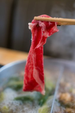 Shabu Shabu 'nun dalış ve düşüşü için sıcak çorba yerine çubuk çiğ et seçiyorum. Popüler yiyecekler parça parça pişirilir, sosla ya da çiğ yumurtayla yenir.