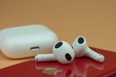 Bangkok, Tayland - 14 Aralık 2022: 3 nesil kırmızı iPhone takıldı. Elma şirketinin kulaklıkları.