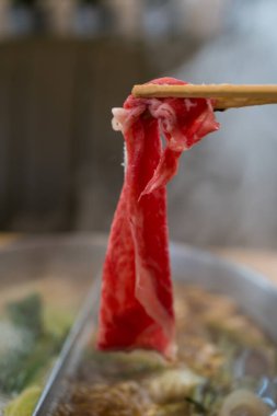 Shabu Shabu 'nun dalış ve düşüşü için sıcak çorba yerine çubuk çiğ et seçiyorum. Popüler yiyecekler parça parça pişirilir, sosla ya da çiğ yumurtayla yenir.