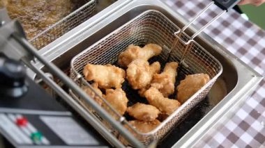 Kızartma makinesinde kızgın yağlı tavuğun yavaş çekim görüntüsü. 