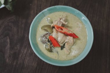 Tahta arka planda Tayland yemeği yeşil körili tavuk manzarası. Thai 'nin adı Gaeng Keow Wan Ga