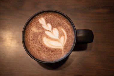 Cup of hot mocha with latte art on the table, directly above view