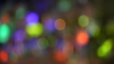 Abstract blurred multicolored light bokeh background with people walk through