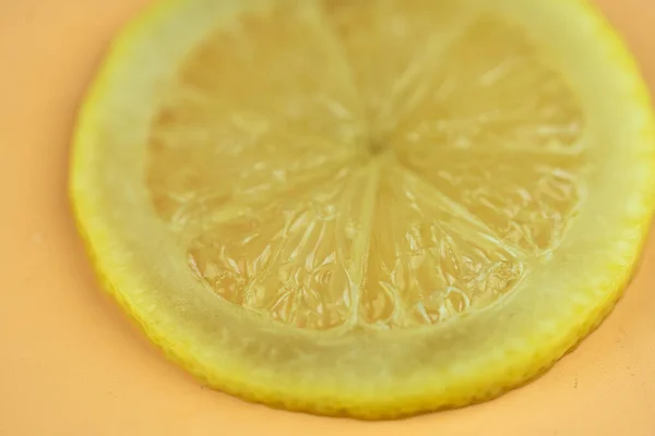 A slice lemon fruit is cut in half, macro photography. Juicy yellow slice of lemon