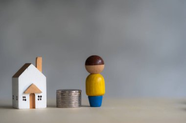 Wooden doll people, stack coins with the house. Property investment, saving for the future and buy a house, getting insurance or loan real estate or property background.