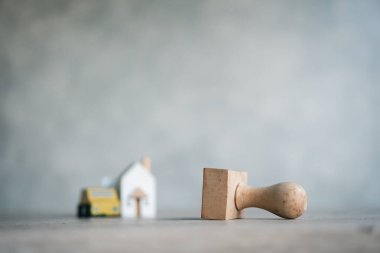 The concept of approval home and car. Financial loan negotiation for lender and borrower on business document mortgage loan approval. Close up of wood stamp and blur background wood home and car