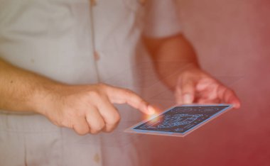 Close up of a engineer hand is using a futuristic latest innovative technology glass tablet with augmented reality holograms as a remote control of smart factory or lab appliances