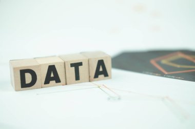 DATA word written on wooden cubes with copy space on paper graph. Research study or information analysis.