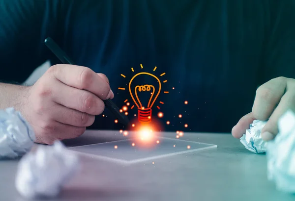 Man hand use a pen with a light bulb icon, creativity, and innovation are keys to success. Creative thinking ideas and innovative concepts. Innovation and new ideas lightbulb concept, find ideas