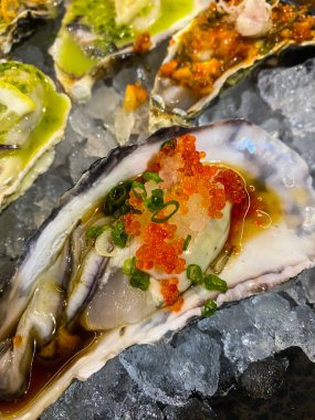 Japon istiridyeleri Japon restoranında alabalık yumurtasıyla süslenir. Kapat.