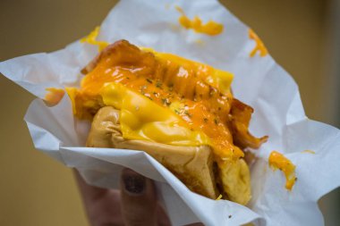 Krem peynirli ve kabarık yumurtalı sandviç. Kadın eli için mükemmel kahvaltı.