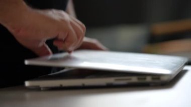 Eller dizüstü bilgisayarı açsın ve yazmaya başlasın. Merkez ofis masası çevrimiçi çalışıyor, bilgisayarı açıyor ve çalışmaya başlıyor.