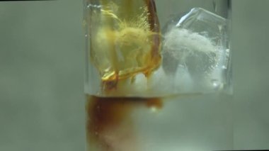 Yavaş çekimde taze kahveyi buz küplerinin üzerine soğuk suyla doldurur. Kahve ve buz karışımı.