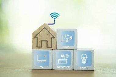 Yenilikçi teknolojinin odun bloğunda ev ya da işyerindeki akıllı ev aletlerinin uzaktan kumandası. Akıllı ev denetimi kavramı.