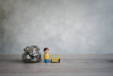 Cam şişelerdeki madeni paralar, araba ve insan modelleri fotokopi alanı, iş tasarrufu ve yatırım kavramları. Tasarruf ve finans hesapları.